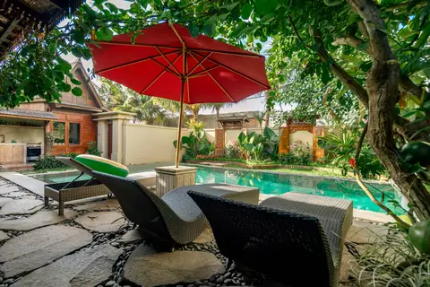 Rumah Elfi: sun loungers under a red parasol by the pool