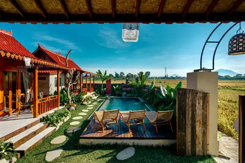 Joglo Hati: pool and wooden houses seen from the veranda