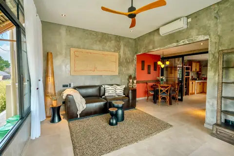 Joglo Hati: living room with a leather sofa and dining area