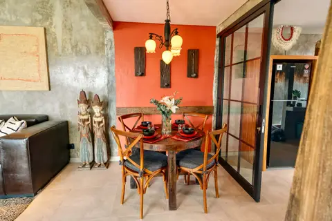 Joglo Hati: dining table in front of the red wall