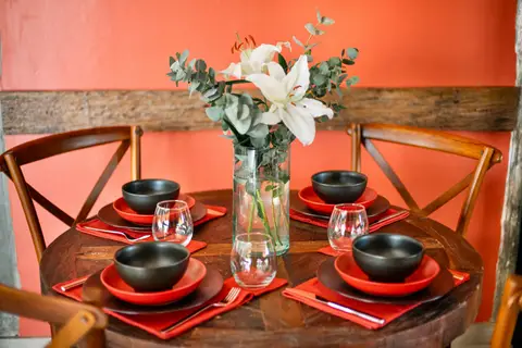 Joglo Hati: dining table set with black bowls and flowers