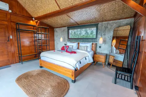 Joglo Hati: Madu bedroom with a double bed and wooden walls