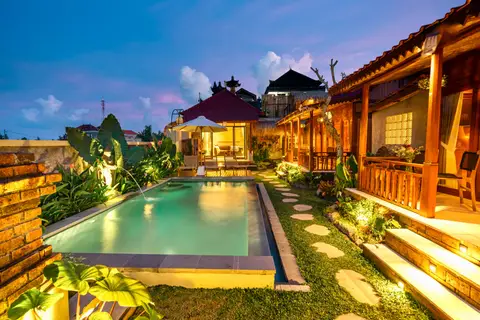 Joglo Hati: lit pool and garden at night