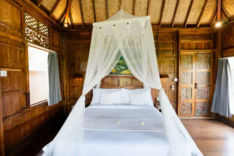 Rumah Richard: four-poster bed with a mosquito net in the first cottage