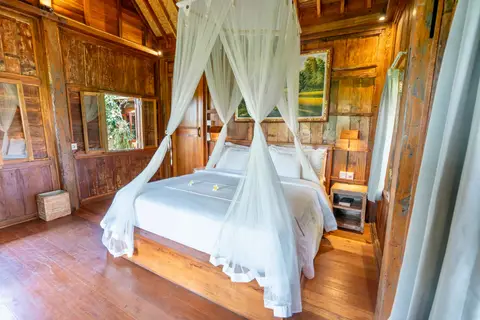Rumah Richard: bedroom of the second cottage with a mosquito net
