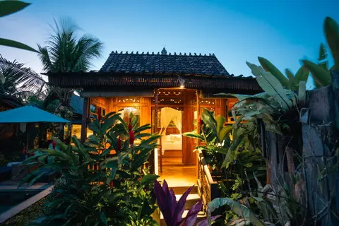 Rumah Richard: cottage under palm trees at dusk