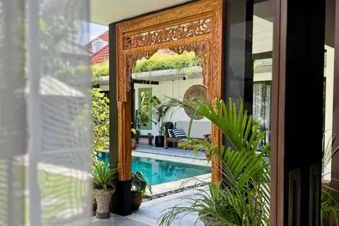 Villa Mint Dua: carved wooden door frame with a view of the pool